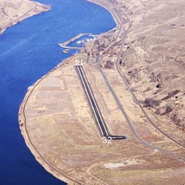 Lower Granite State Airport runway with a body of water on the left and grass fields to the right