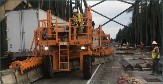 A moveable barrier with workers on a bridge