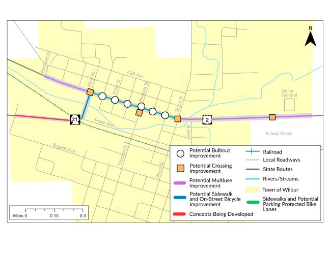 Detailed map of the town of Wilbur, focusing on potential transportation and infrastructure improvements. The map highlights various streets and features a legend in the bottom right corner. Colored lines and symbols indicate different types of improvements: potential bulbout improvements (white circles), potential crossing improvements (orange squares), potential multiuse improvements (purple lines), potential sidewalk and on-street bicycle improvements (blue lines).
